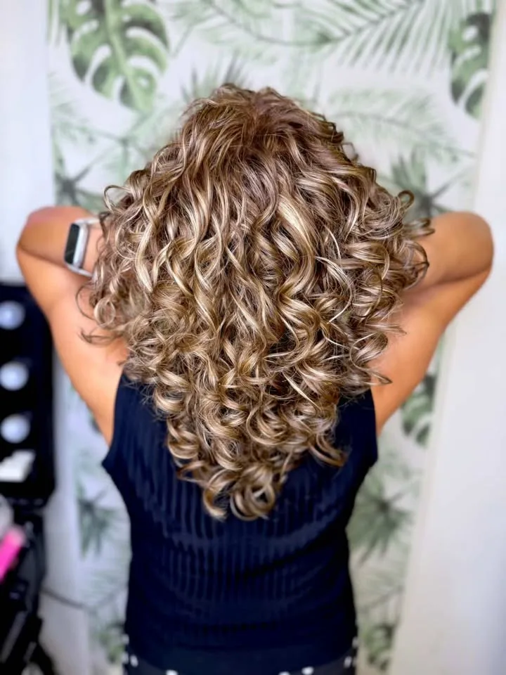 Después: rizos definidos con mechas rubias